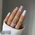 عکس ناخن مصنوعی رنگ صورتی مات با طرح قلب های سفید و نگین کاری شده و ناخن تک رنگ سفید براق فرم مربعی بلند مدل RSN0048 برند راسا