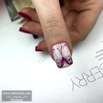 عکس ناخن مصنوعی طرح پروانه بنفش و سفید نقاشی شده روی زمینه اکلیلی براق فرم مربعی کوتاه مدل RSN0065 برند راسا