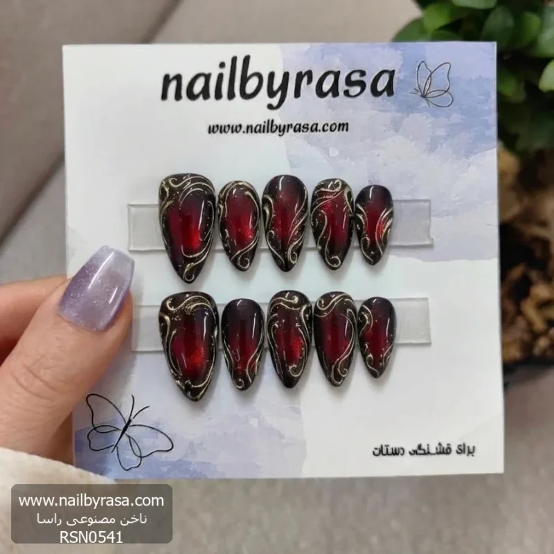 ناخن مصنوعی طرح پیچک سلطنتی زرشکی و طلایی استایلتو راسا RSN0541، مناسب مجالس و مهمانی‌ها. طراحی لوکس و فانتزی با رنگ‌های غنی و خطوط طلایی ظریف.